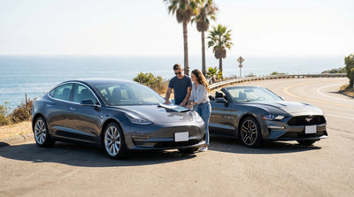 A modern car rental driving on a scenic coastal highway in California with the Pacific Ocean in the background