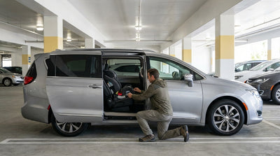 A parent fits a child safety seat into the back of their New York car rental vehicle at the airport