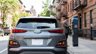 Close-up of a temporary paper license plate on the back of a silver car rental vehicle in New York
