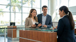 A traveler showing a payment card to an agent at a bright car hire desk in Miami