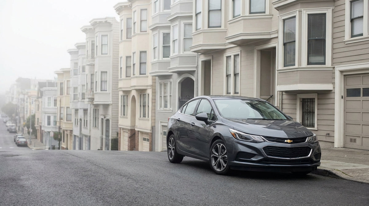 A car rental parked on a steep residential street in San Francisco with classic Victorian homes in the background