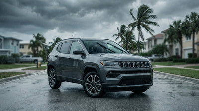 A car hire driving on a wet street in Miami as storm clouds gather and palm trees sway in the wind