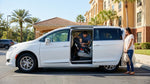 A child seat installed in the back of a car rental vehicle parked near palm trees in Orlando