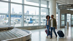 A traveler with luggage standing at a car rental counter in San Francisco airport