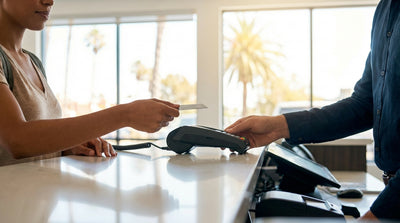 A white car rental parked on a scenic coastal highway in California overlooking the Pacific Ocean