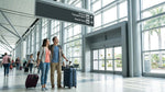 Travelers with luggage wait by the curb for a car rental shuttle bus at LAX in Los Angeles