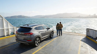 A car hire vehicle on a ferry crossing San Francisco Bay with the Golden Gate Bridge in the distance