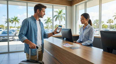 A red convertible car hire parked on a sunny road beside a beautiful Florida beach with palm trees