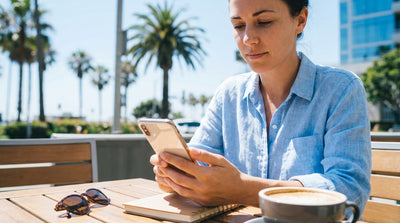 A convertible car rental driving down a scenic, winding highway next to the ocean in California