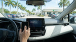 Person touching a dashboard touchscreen from the driver seat of a Florida car rental