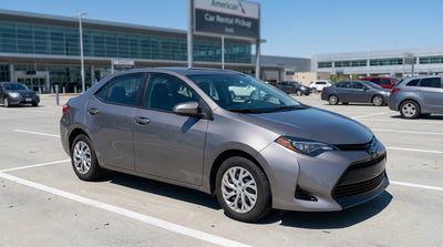 A red convertible car rental on an open desert road in the United States under a bright blue sky