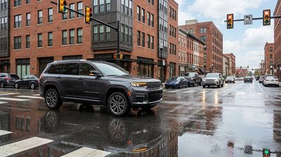 A car hire navigates a busy intersection with traffic lights on a street in Pittsburgh, Pennsylvania