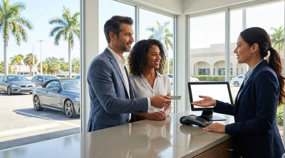 A convertible car hire on Ocean Drive in Miami with colorful art deco hotels in the background