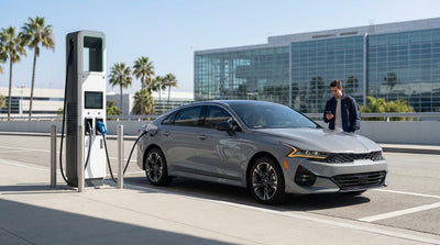 A driver plugs in an electric car rental at a fast-charging station on a sunny Los Angeles street