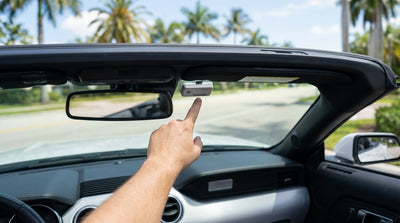 A driver inspects the windshield of their Florida car hire for a toll transponder before leaving the lot