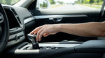 Driver's hand on the automatic gear shift of a car rental on a scenic highway in the United Estates