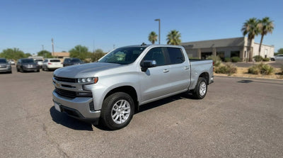 A modern sedan car rental driving on a scenic highway through the rolling hills of the Texas Hill Country at sunset