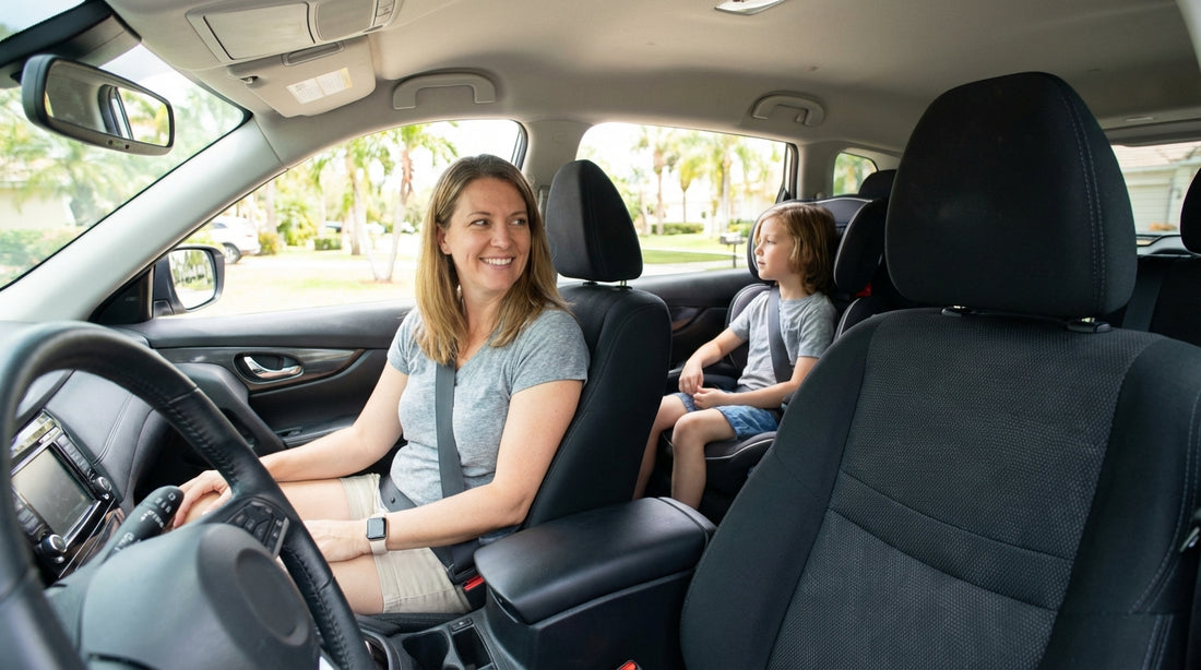 A mother smiling as she buckles her child into the back of their car rental on a sunny day in Orlando