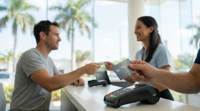 A convertible car hire driving down a sun-drenched Miami road lined with tall palm trees