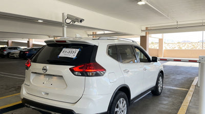 A car hire with temporary license plates approaches an automated parking garage barrier on the Las Vegas Strip