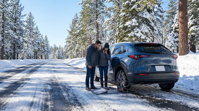 A car hire vehicle drives on a scenic, snow-covered mountain road on a sunny winter day in California