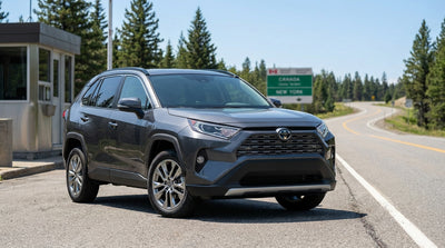 A modern car rental parked on a street in New York with the Brooklyn Bridge in the background at sunset