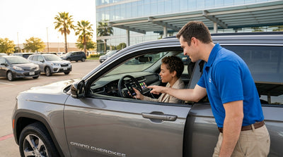 A person's hands connecting a smartphone to the dashboard of a modern car rental in Texas to set up Android Auto