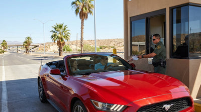 A car rental driving south on a sunny California highway towards the Mexico border