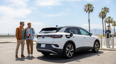 An electric car rental charging at a public station on a sunny day with palm trees in California