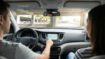 A driver tests the sat-nav screen in a modern car hire vehicle in sunny Miami