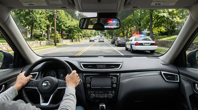 A car rental stopped by police with flashing lights on a narrow New York parkway with no shoulder