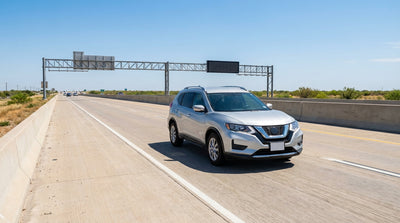 A car rental driving on a multi-lane Texas highway with blue TEXpress toll lane signs overhead