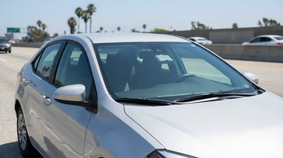 A car rental driving on a sunny, multi-lane freeway in Los Angeles next to the carpool lane
