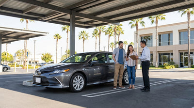 A convertible car rental driving along a sunny, winding coastal highway in California