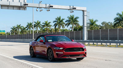 A car rental driving on a sunny highway in Orlando and approaching a toll plaza