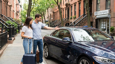 A modern car rental drives through the bright, busy streets of Times Square in Manhattan, New York