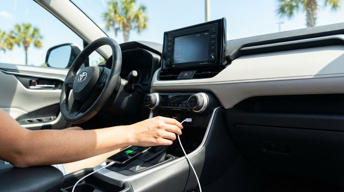 A person's hand plugging a phone charger into the USB port of a car hire in Orlando