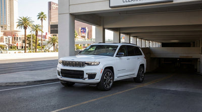 A car hire drives toward a Las Vegas hotel parking garage with a yellow height restriction bar at the entrance