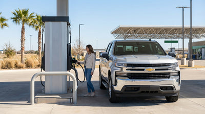 A modern car rental drives down a long, empty highway through the scenic desert landscape of Texas
