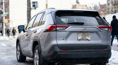 Rear of a car hire parked in New York City with its license plate completely covered by fresh winter snow