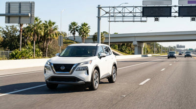A white car rental traveling on the I-4 highway in Orlando near the entrance to the express lanes