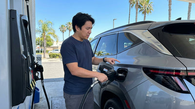 Close-up of a car rental dashboard with the fuel gauge on empty while driving on a sunny California highway