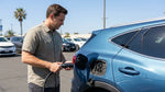 A sleek electric car rental charging at a station with California palm trees in the background