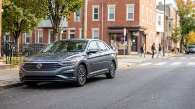 A car rental vehicle parked on the left on a one-way street with brick homes in Philadelphia, Pennsylvania