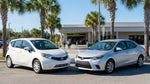 Silver economy and white compact cars parked near palm trees on a sunny Florida street during a car hire trip