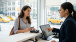 A person at a car hire desk in a New York airport looks concerned while reviewing their booking details