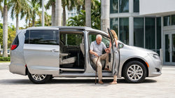 Spacious SUV car hire parked on a sunny Miami street with a wheelchair positioned next to the open driver door