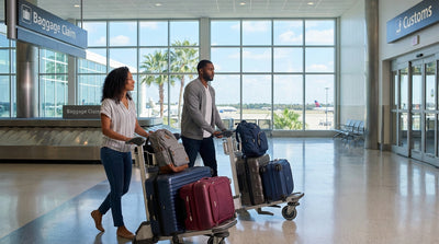 Travelers with luggage walk through Orlando airport to find their car rental desk