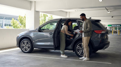 A person carefully installs a child safety seat into the back of a Pennsylvania car hire SUV
