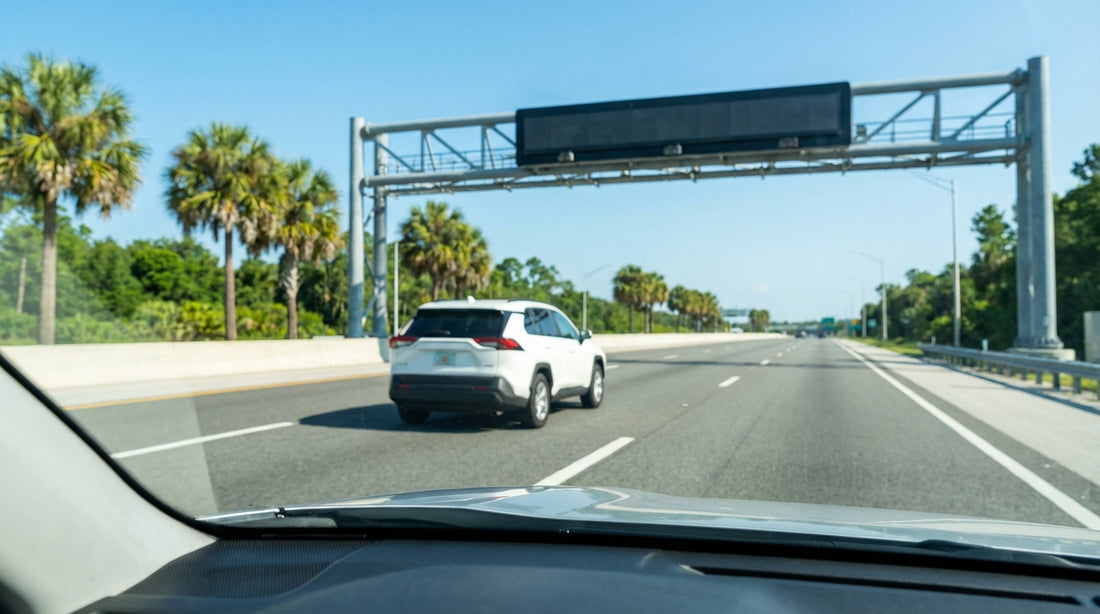 A modern car hire driving on a busy expressway in Orlando under a large green highway sign